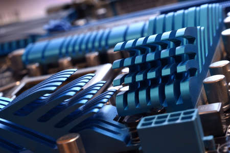 Detail of a blue aluminum heatsink on a modern pc motherboard. selective focus.