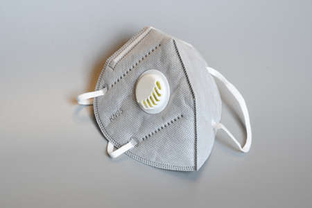 KN95 or N95 mask with valve for protection pm 2.5 and corona virus on gray background. Prevention of the spread of virus and pandemic COVID-19.の写真素材