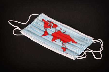 Face mask with world map. Covid-19 epidemic around the world. Life in isolation around the world. Concept of coronavirus disease and world crisis.の写真素材