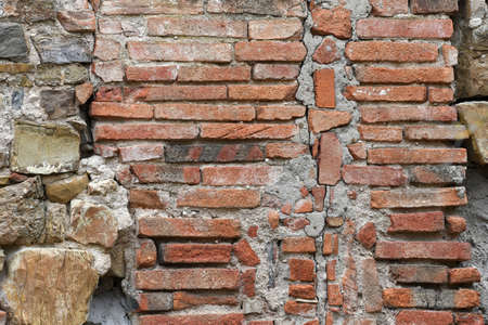 stone and red brick wall of old abandoned and dilapidated house in the Tuscan countryside in Italyの写真素材