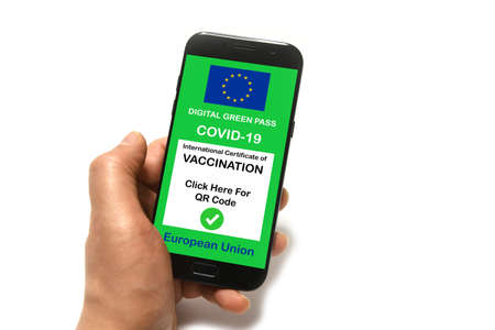 The digital green pass of the European Union with the QR code on the screen of a smartphone held by hands isolated on white backgroundの写真素材