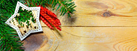 Christmas banner with fir tree branch and decorations on wooden background