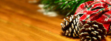 Christmas banner with fir tree branch, pine cones and decorations on wooden backgroundの写真素材