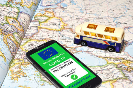 The digital green pass of the European Union on smartphone with a model of pulmann over a geographical map.の写真素材