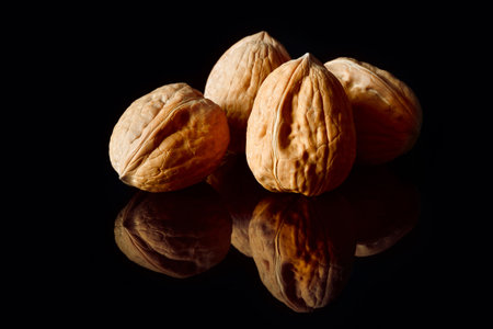 Close up of Walnuts on black reflective background
