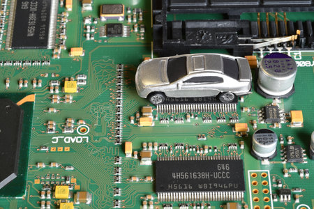 Toy cars on electronic board and microchip. The shortage of microchips and semiconductors creates a...