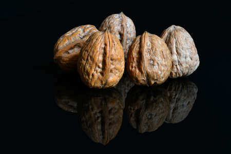 walnuts on black reflective background