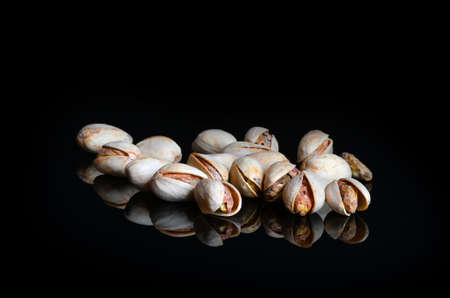 pistachios isolated on black reflective background