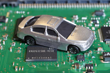 Toy cars on electronic board and microchip. Conceptual image for semiconductor shortage disrupting production of the automotive industry.の写真素材