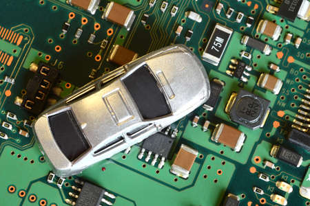 Toy cars on electronic board and microchip. Conceptual image for semiconductor shortage disrupting...