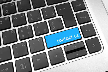 text "contact us" on blue key of computer keyboard. Internet or online contact through the website.の写真素材