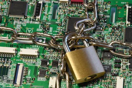 Computer security concept. Iron chain and padlock on green computer circuit.