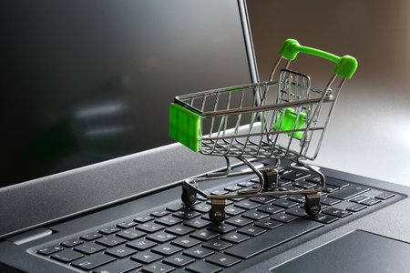 Online shopping. Shopping cart on a laptop keyboard. Concept for online shopping.の写真素材