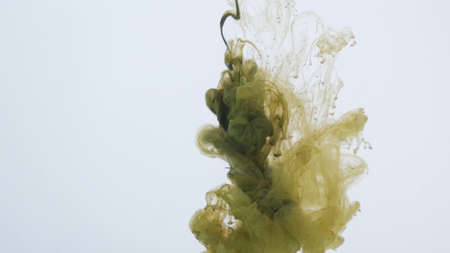 Green paint explodes and sprays in the water on a white backgroundの写真素材