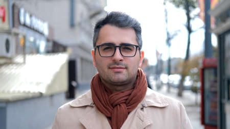 A man of Eastern appearance, a poet and artist with glasses looks at the camera