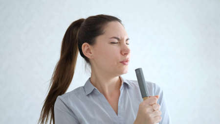 A girl dances and sings with a mop. Good mood. A young woman is cleaning
