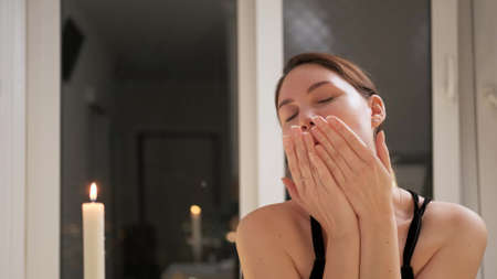 A charming woman in an evening dress blows a air kiss to the camera. Romantic date in a restaurant....
