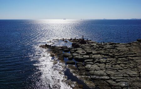 Lighthouse on the rocky seashoreの写真素材