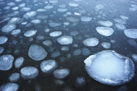 pieces of ice melt in the gray water