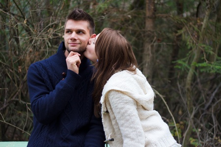 Young couple holding hands in the forest in front of treesの写真素材