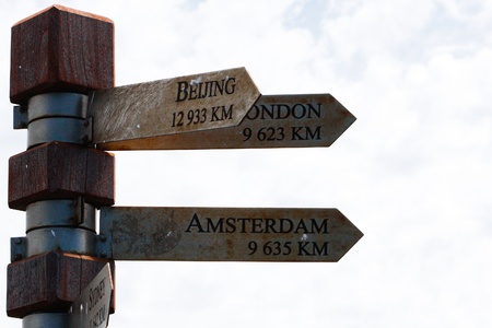 A Signpost shwoing to Beijing, London and Amsterdam Including the Distanceの写真素材