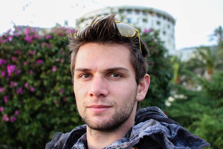 Young Man Sitting Outdoors And Thinkingの写真素材