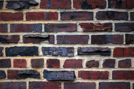 An old brick wall with interesting texture and dark black marksの写真素材