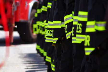 A photo of NYC firefighters line up with the backs of their coats showingの写真素材