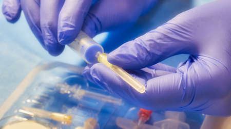 Doctor's hands hold a new syringe. Soft filter on the imageの写真素材