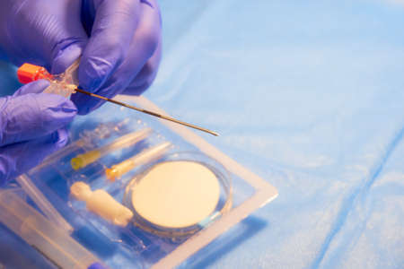 Epidural needle. Tuohy needle in doctor's hands. Color filters, soft focus effectの写真素材