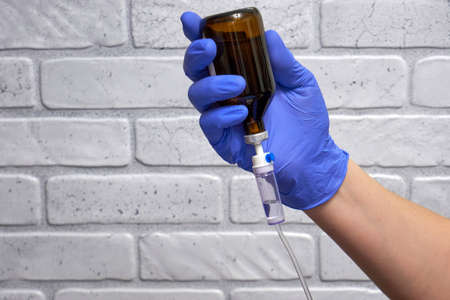 Medical dropper and doctor's hand in a glove