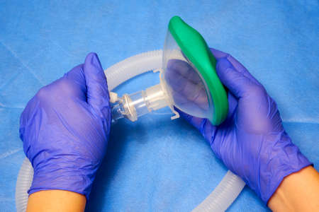 Modern disposable anesthesia mask in the hands of a medic