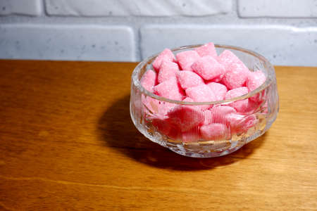 Crystal bowl with pink sweets on the tableの写真素材