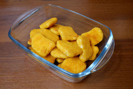 Fried nuggets in a glass form on a wooden tableの写真素材