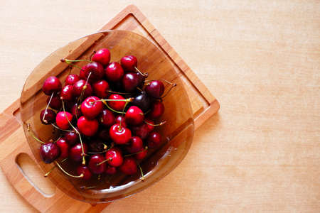 Cherries in a glass plate on the table