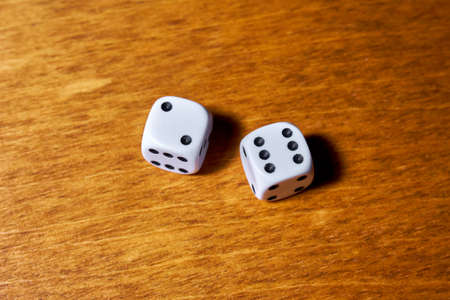 Two white dice on a wooden table