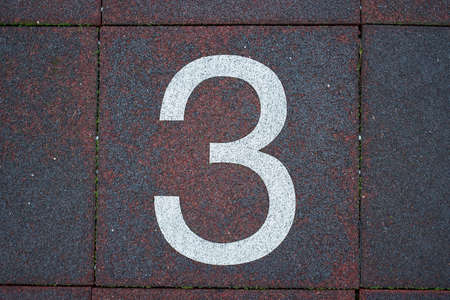 Number 3 in white on urban street tile