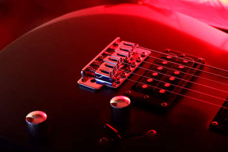 Electric guitar illuminated by red lightの写真素材