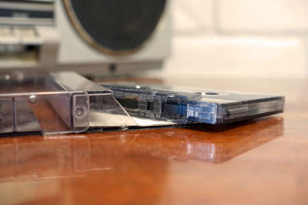 Compact cassette on the background of a stereo tape recorder. Old audio recordings