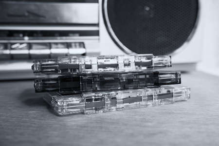 Audio cassettes without boxes lie on the table against the background of a tape recorderの写真素材