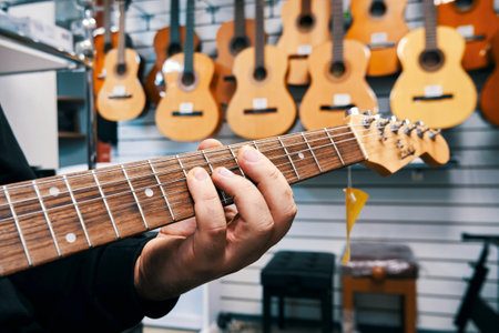 Ryazan, Russia - October 9, 2022: Professional musician demonstrating a guitar in a music storeのeditorial素材