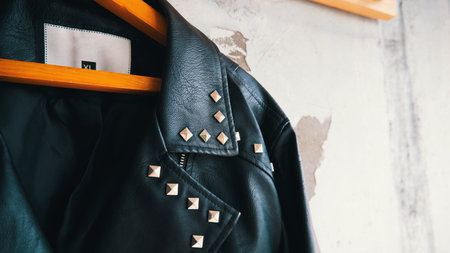 Close-up of leather jacket hanging on wooden hangerの写真素材