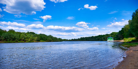 Widescreen landscape with river view and blue sky with white clouds