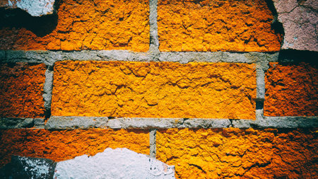 Red brick wall with pieces of peeling plaster. Vintage camera filter added to imageの写真素材
