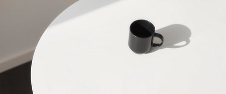 Black coffee cup on empty round white table. Minimalismの素材