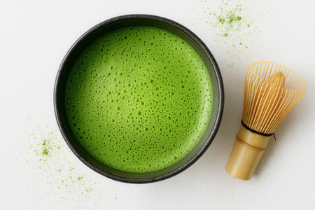 Matcha green tea in a bowl and whisk on a white backgroundの素材
