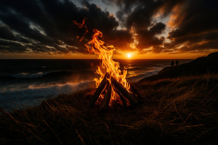 Bonfire on the beach at sunset. Beautiful landscape of a burning bonfire on the beach.の素材