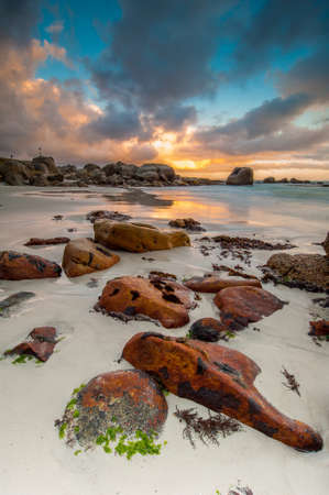 Long exposure photography of waves crashing over rocks at sunrise with storm clouds buildingの写真素材