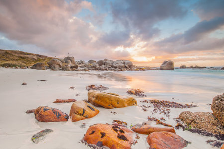 Long exposure photography of waves crashing over rocks at sunrise with storm clouds buildingの写真素材