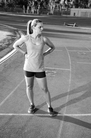 An athletic looking female runner on an outdoor track in summerの写真素材